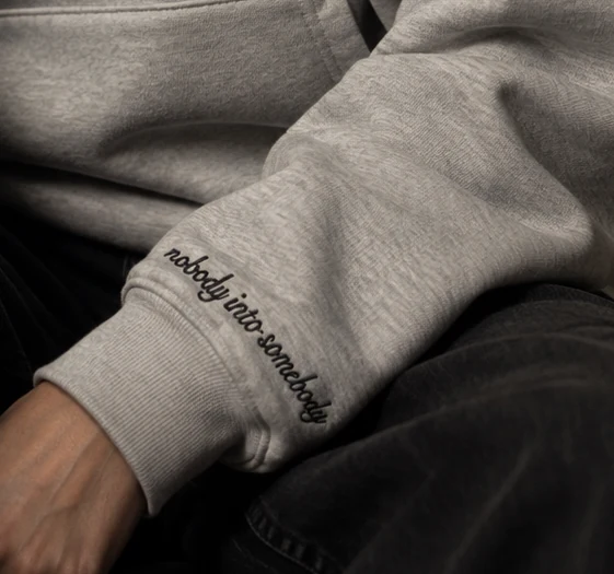nobody into somebody embroidered above the left cuff